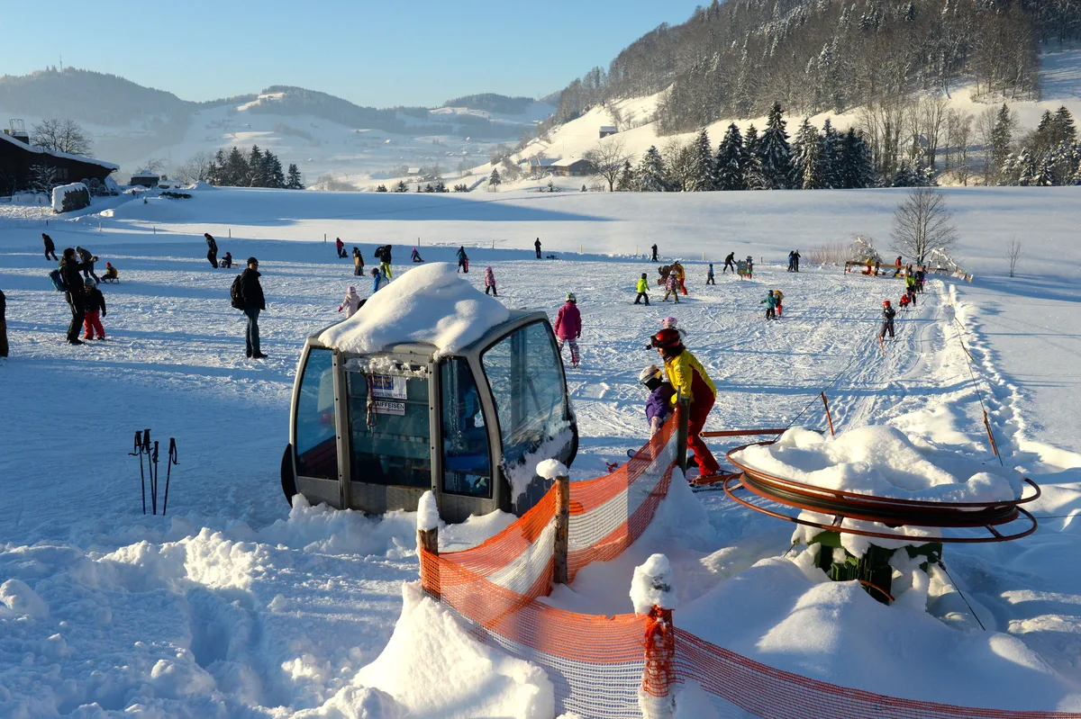 Eine Skipiste mit Kindern und einem kleinen Ponylift.